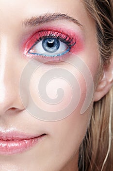 Closeup macro shot of female face and pink smoky eyes makeup