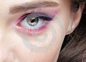 Closeup macro shot of  human female eye with  pink  eyes shadows