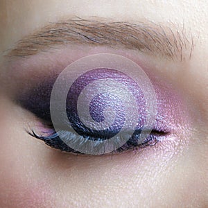 Closeup macro shot of human female eye. Woman with lilac beauty eyes makeup