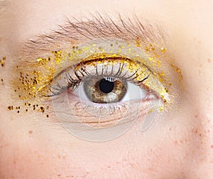 Closeup macro shot of human female eye with yellow smoky eyes beauty makeup