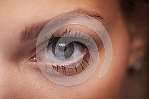 Closeup macro shot of human teenager female eye. Woman with natural face beauty makeup.