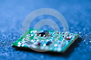 Closeup Macro Shot of Miniature Printed Circuit Board Against Blue Material Surgace with Surface Mounted Components