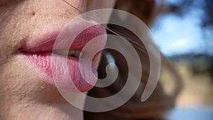 Closeup macro shot sexy lips of beautiful young woman outdoors