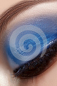 Closeup Macro of Woman Face with Blue Eyes Make-up. Fashion Celebrate Makeup, Glowy Wet Eye Shadows and Black Eyelashes