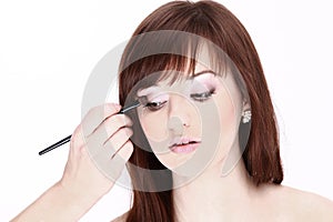 Closeup.Makeup artist applies eye shadow. Beautiful woman face