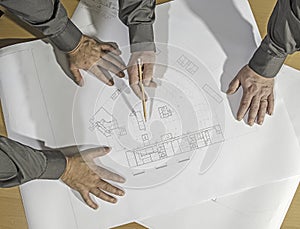 Closeup Of Male Architects Working On Blueprint At Office.