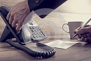 Closeup of male assistant about to answer a telephone call