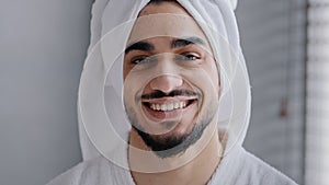 Closeup male face with acne headshot portrait smiling toothy handsome arabian indian bearded man with bath towel on head