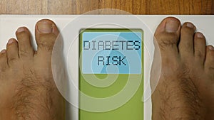 Closeup male feet on scale DIABETES RISK blinking display at morning 4k footage top view