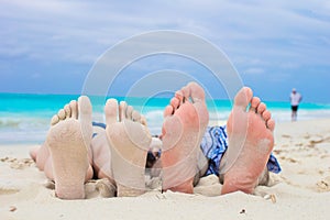 Closeup male and female feet on white sand
