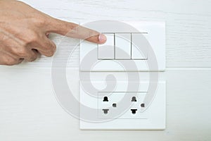 Closeup Male finger is turn on or off on light switch on white wall at home. Energy Saving, power, electrical and lifestyle