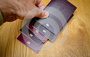 Closeup of male hand arranging multiple biometric passports with embedded