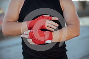 Closeup male hand of boxer with red boxing bandages