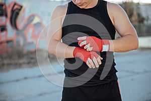 Closeup male hand of boxer with red boxing bandages