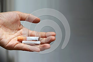 Closeup of male hand holding broken cigarette on palm