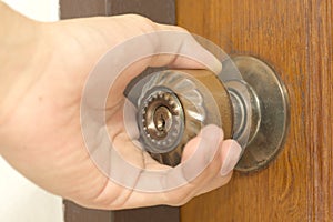 Closeup of male hand opening door knob photo