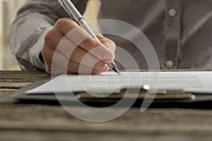 Closeup of male hand signing business contract or document