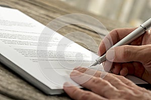 Closeup of male hand signing a contract or application form