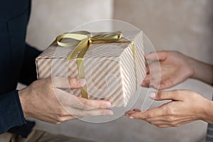 Closeup male hands giving long-awaited gift to sweetheart wife