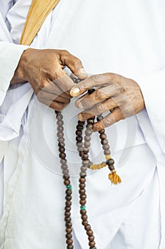 Closeup male hands holding a rosary or prayer beads