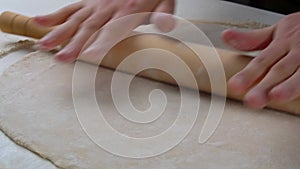 Closeup of male hands making delicious traditional pizza. Chef rolling out dough with rolling pin