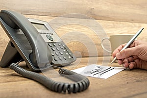 Closeup of male receptionist writing the word Urgent