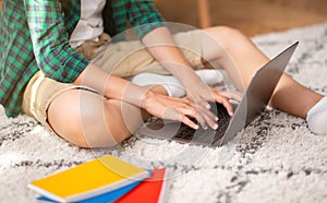 Closeup of male schooler typing on laptop, doing homework