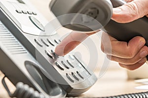 Closeup of male telemarketing salesperson holding a telephone re photo