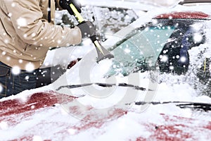Closeup of man cleaning snow from car