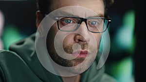 Closeup man coder working night datacenter. Serious developer looking computer