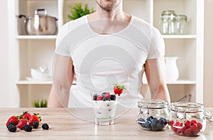 Closeup on man with delicious yoghurt with fresh berries