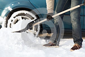 Closeup of man digging up stuck in snow car photo