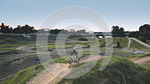 Closeup man drive bicycle on dirt road aerial. Summer nature landscape. Young traveler ride on bike