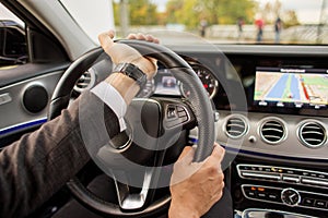 Closeup of man driving a car holding steering wheel