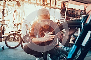 Closeup of Man Examines Bicycle Wheel in Workshop