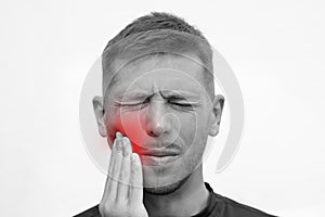 Closeup of man face with strong tooth pain. Man suffering from toothache or feeling tooth pain