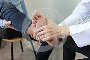 Closeup of Man feeling pain in her foot and doctor the traumatologist examines or treatment on white background, Healthy concept