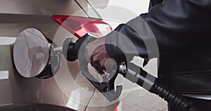 Closeup of man filling benzine gasoline fuel in car at gas station. African American Man Refueling Car At Gas Station