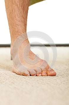 Closeup of man foot standing on carpet