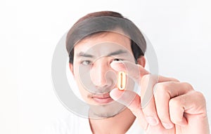 Closeup man hand holding fish oil medicine with white background