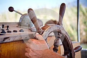 Closeup man hand holding a sailing vessel wheel.