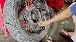 Closeup man hands inflate scooter wheel tire in shop