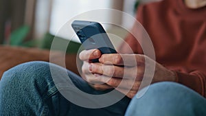 Closeup man hands messaging smartphone at home close up. Cheerful guy laughing