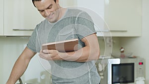 Closeup man hands with tablet cooking healthy food at home kitchen.