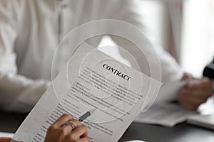 Closeup man holding pen reading terms and conditions of contract