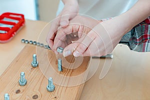 Closeup of man in occupational therapy screwing nut on bolt