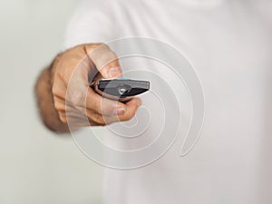 Closeup of a man pess the remote controller button on white background