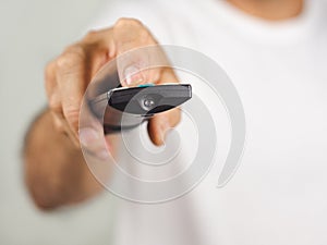 Closeup of a man pess the remote controller button on white background