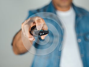 Closeup of a man pess the remote controller button on white background