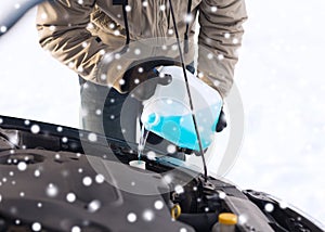 Closeup of man pouring antifreeze into car